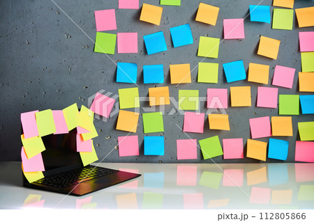 Office workplace with laptop and blank colorful sticky notes reminders 112805866