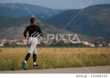 A determined woman athlete trains for success in the morning sun. 112806120