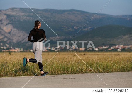 A determined woman athlete trains for success in the morning sun. 112806210