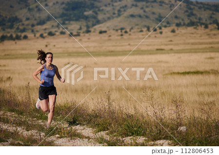 A determined woman athlete trains for success in the morning sun. 112806453