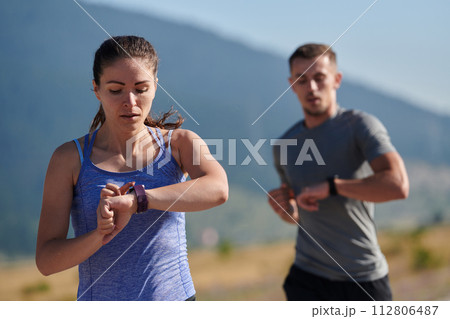 Energized by the beauty of nature, a couple powers through their morning run, their bodies and spirits invigorated. 112806487