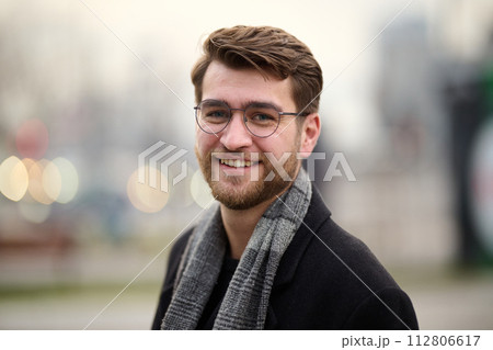 A handsome young man, dressed in a stylish suit, tie, and glasses, exudes the appearance of a serious and confident businessman A handsome young man, dressed in a stylish suit, tie, and glasses, exudes the appearance of a serious and confident businessman 112806617