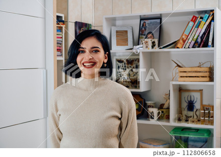 A Portrait of Beauty: A Black-Haired Woman Bathes in the Warm Light of Her Living Room 112806658