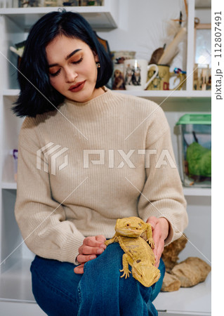 Beautiful Woman Posing with Her Two Adorable Bearded Dragon Pets 112807491