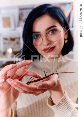 Young Woman Captured in a Beautiful Moment with Her Stick Insect (Medauroidea Extradentata) 112807610