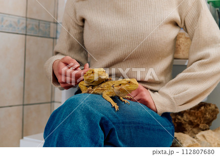 Beautiful Woman Posing with Her Two Adorable Bearded Dragon Pets Beautiful Woman Posing with Her Two Adorable Bearded Dragon Pets 112807680