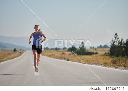 A determined woman athlete trains for success in the morning sun. 112807941