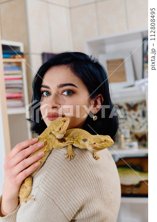 Beautiful Woman Posing with Her Two Adorable Bearded Dragon Pets 112808495