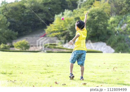 公園でボールで遊ぶ幼い子供の後姿 公園でボールで遊ぶ幼い子供の後姿 112809499