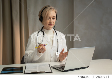 Female Physician Conducting a Virtual Health Consultation in Her Office Female Physician Conducting a Virtual Health Consultation in Her Office 112809751