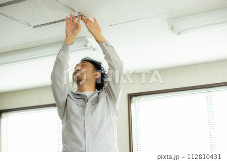 天井を点検する作業着の男性　 　 112810431