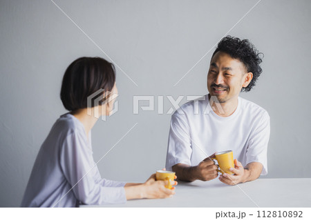マグカップを持って話をするカップル  112810892