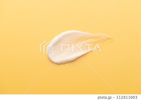 Skincare cream smear on yellow background. Cosmetic lotion swatch texture of sunscreen, face cream, body moisturiser and hair conditioner. Beauty and cosmetic product. 112811003