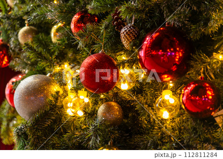 Beautiful Christmas ornament hung on lit tree 112811284