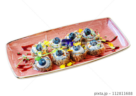 Traditional Japanese dish hot sushi Philadelphia fried in a plate decorated with flower petals. On white isolated background. 112811688