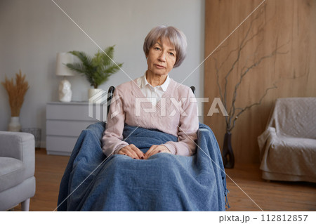 Retired woman with disability sitting in wheelchair 112812857