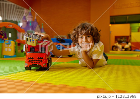 Boy child playing vehicle toys at kids care center Boy child playing vehicle toys at kids care center 112812969