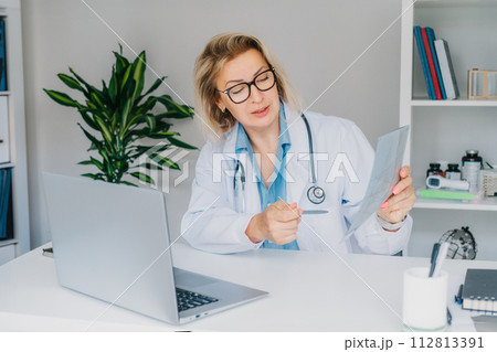 Female doctor makes online video call consult patient on laptop. Middle aged woman therapist videoconferencing for domestic health treatment. Telemedicine concept. Online remote medical appointment. 112813391