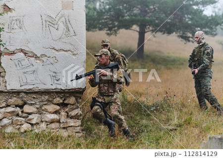 In a high stakes mission, a specialized military unit executes a tactical operation to secure a dangerous house where terrorists are believed to be hiding, showcasing precision and coordinated 112814129