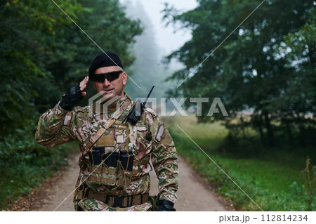 A dedicated soldier salutes his elite unit, showcasing camaraderie and readiness for the most perilous military operations 112814234