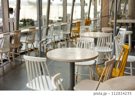 Interior of a empty restaurant. Empty restaurant tables near windows 112814235