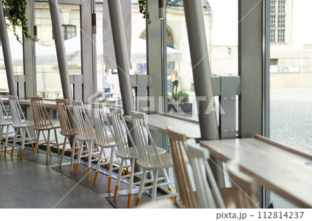 Interior of a empty restaurant. Empty restaurant tables near windows 112814237