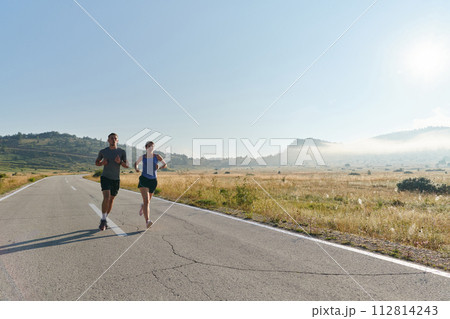 Energized by the beauty of nature, a couple powers through their morning run, their bodies and spirits invigorated. 112814243