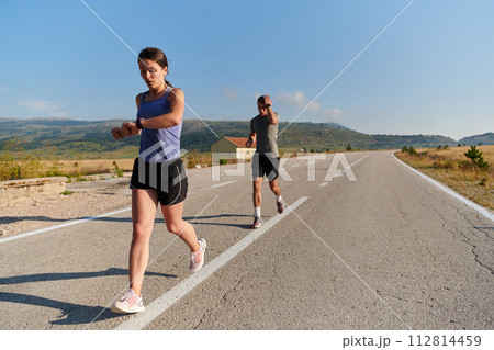 Energized by the beauty of nature, a couple powers through their morning run, their bodies and spirits invigorated. Energized by the beauty of nature, a couple powers through their morning run, their bodies and spirits invigorated. 112814459