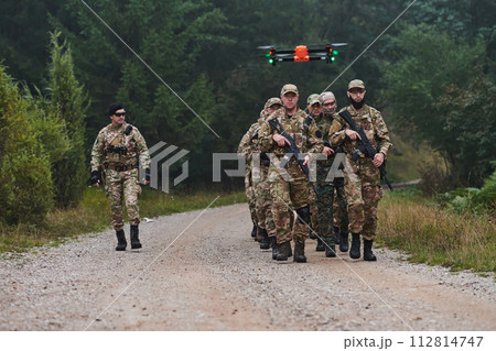 An elite military unit, led by a major, confidently parades through dense forest, showcasing precision, discipline, and readiness for high-risk operations 112814747