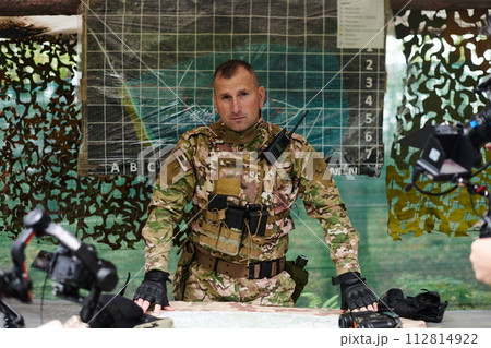 The esteemed leader of an elite military unit, strategic brilliance unfolds as he meticulously devises tactical plans for the upcoming military operation, surrounded by cutting-edge technology and a 112814922