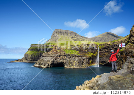 Tourist Near Mulafossur Waterfall in Gasadalur, Faroe Islands 112814976