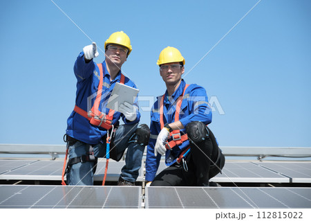 Engineers install solae cell on the roof of factory 112815022