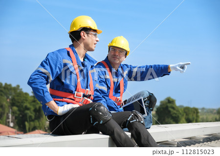 Engineers install solae cell on the roof of factory 112815023