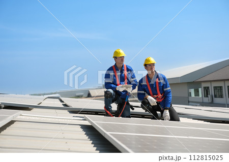 Engineers install solae cell on the roof of factory Engineers install solae cell on the roof of factory 112815025