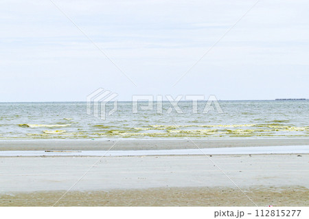Green dark sea water wave natural phenomenon with brown sand beach. Seawater in Bang Saen, Chonburi Province, has turned green. Natural phenomenon. During rainy season called Plankton bloom Green dark sea water wave natural phenomenon with brown sand beach. Seawater in Bang Saen, Chonburi Province, has turned green. Natural phenomenon. During rainy season called Plankton bloom 112815277