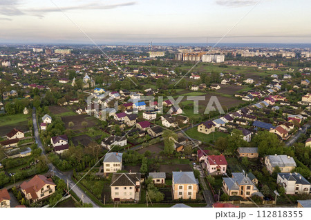 Aerial landscape of small town or village with rows of residential homes and green trees. 112818355