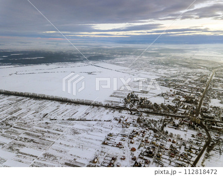 Top view of empty snowy fields on winter morning on dramatic cloudy sky background. Aerial drone photography concept. Top view of empty snowy fields on winter morning on dramatic cloudy sky background. Aerial drone photography concept. 112818472
