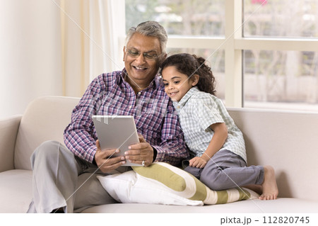 Happy Indian grandfather and little granddaughter girl using tablet 112820745