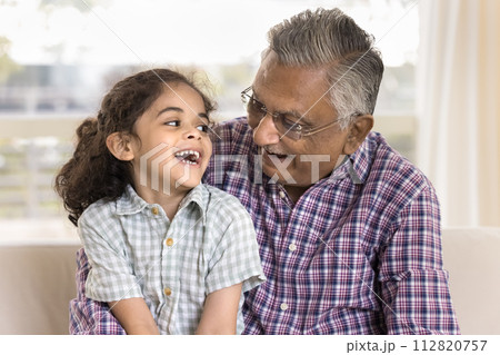 Cheerful senior Indian grandfather holding sweet little granddaughter kid 112820757