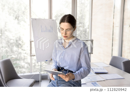 Serious concentrated young office employee working on tablet 112820942