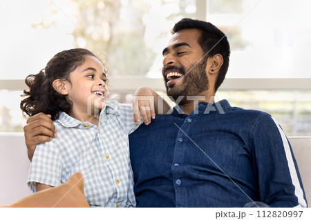 Cheerful caring young Indian dad hugging happy little daughter kid 112820997