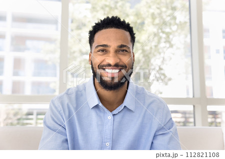Cheerful African freelance business man talking on video conference call 112821108