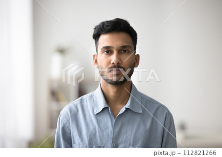 Serious Indian guy in casual blue shirt posing for camera Serious Indian guy in casual blue shirt posing for camera 112821266