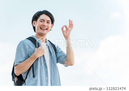 青空の下にいる笑顔の学生・大学生の男性(進学・受験・チャレンジ・希望・目標) 青空の下にいる笑顔の学生・大学生の男性(進学・受験・チャレンジ・希望・目標) 112821474