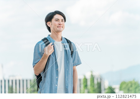 青空の下にいる笑顔の学生・大学生の男性（進学・受験・チャレンジ・希望・目標） 112821475