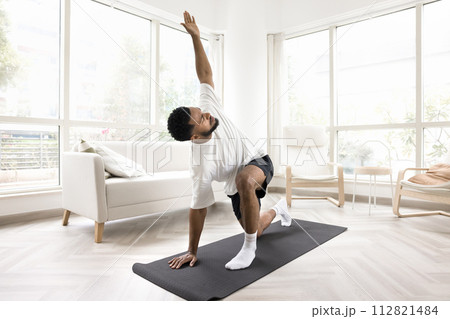 Serious young Black man doing morning exercises at home 112821484