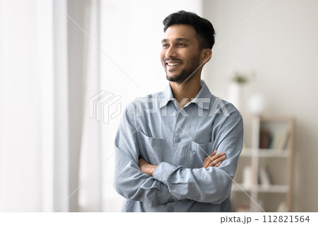 Indian man standing with arms crossed smiling looking away Indian man standing with arms crossed smiling looking away 112821564