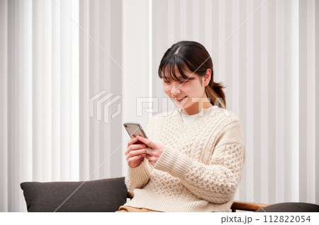 家でスマホを操作する女性 112822054