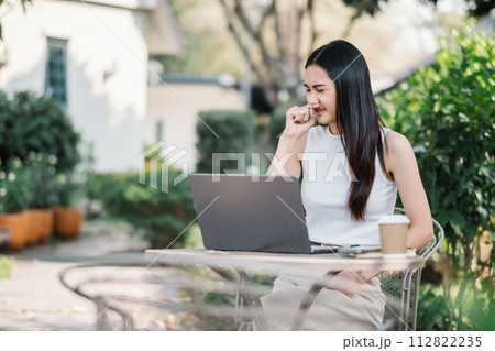 Woman in outdoor garden smelling something stinky and disgusting, intolerable smell, holding breath with fingers on nose. Bad smells concept. 112822235