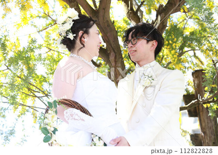 ミモザの花を背景にウエディングドレス姿の新婦様とタキシードの新郎様ロケ撮影のフォトウエディング ミモザの花を背景にウエディングドレス姿の新婦様とタキシードの新郎様ロケ撮影のフォトウエディング 112822828